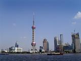 View of Shanghai City Skyline from Huangpu River Featuring Oriental Pearl Tower Against Sunny Blue Sky